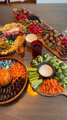 a table filled with lots of different types of food on plates next to candles and wine glasses