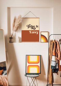 a room with clothes hanging on the wall, and a chair in front of it