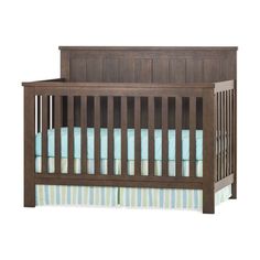 a baby crib with blue and white sheets on it's bottom half, in front of a white background