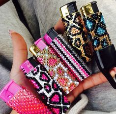 a person holding four different types of lighters in their hands and one is wearing a sweater