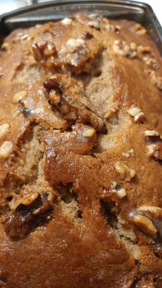 a loaf of bread sitting on top of a pan filled with nuts and raisins