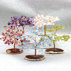 three small trees with different colored leaves on top of each other and one is made out of wood