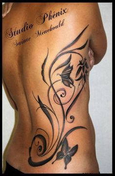 the back of a woman's stomach with flowers and butterflies tattoo on her side