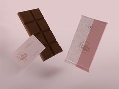 two pieces of chocolate sitting next to each other on a table with a pink and white striped wrapper