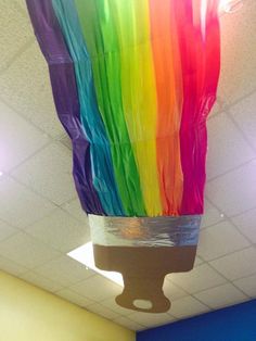 a lamp that has been made to look like a rainbow colored paper lantern hanging from the ceiling