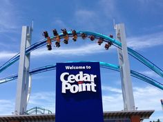 a roller coaster ride going over the top of cedar point amusement park's sign