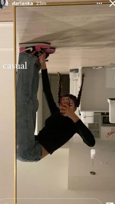 a man is hanging upside down on the ceiling with his skateboard in hand and another person holding a cell phone up above him