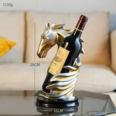 a glass table topped with a bottle of wine and a horse figurine on top of it