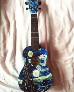 an acoustic guitar painted with the starry night painting on it's body and neck