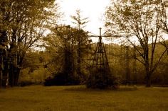 an old fashioned windmill in the middle of a field