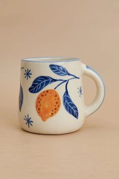 a blue and white coffee cup with an orange design on the inside, sitting on a beige surface