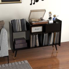 a record player is sitting on top of a shelf next to a couch and chair