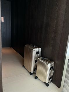 two suitcases sitting next to each other on the floor in front of a wall