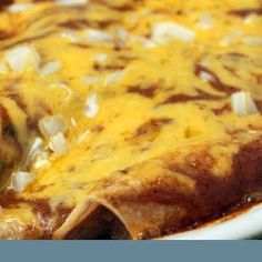 an enchilada dish with cheese and onions in a casserole dish