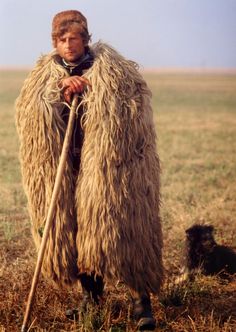 a man in a furry coat holding a stick