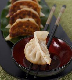 two plates with dumplings and chopsticks on them