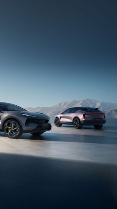 two cars driving on the road in front of each other with mountains in the background