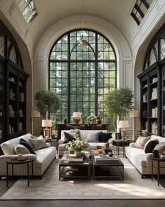 a living room filled with lots of furniture next to a large arched window on top of a wall