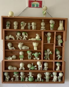 a wooden shelf filled with lots of small figurines