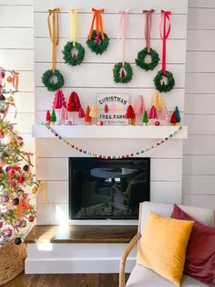 christmas wreaths are hanging on the wall above a fireplace