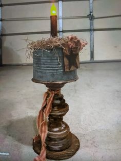 a candle that is sitting on top of a pole in the middle of a room