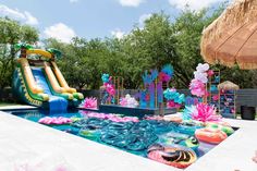 an inflatable water slide and pool are decorated with flowers