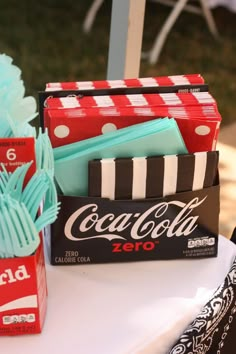 a table topped with candy boxes and coca colas on top of each other's sides