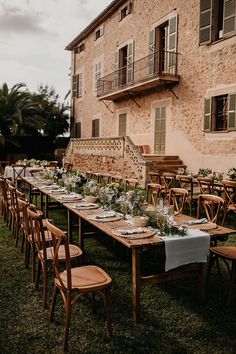 a long table is set up outside in front of an old building