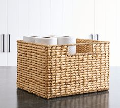 a wicker basket with two rolls of toilet paper in it on a countertop