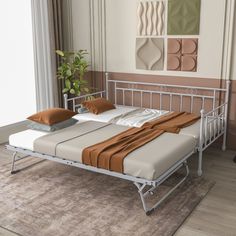 a white metal bed frame with two pillows on it and a plant in the corner