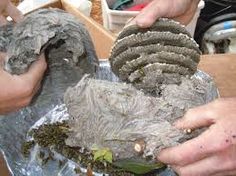 two hands are holding an object that looks like it has been made out of cement