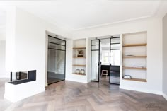 an empty living room with white walls and wood flooring on the wooden parquet