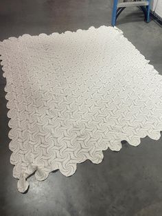 a large white quilt on the ground in a warehouse