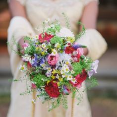 a bride holding a bouquet of flowers in her hands