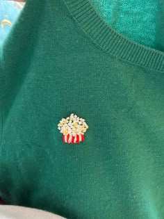 a green sweater with popcorn on it