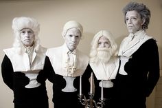 three men in white wigs stand next to each other