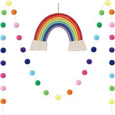 a rainbow decoration with pom - poms and tassels hanging from it