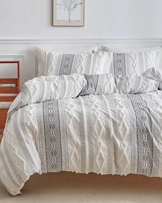 a bed with white and black comforter in a bedroom