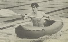 an old photo of a shirtless man in a raft paddling down the water