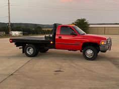 a red pick up truck parked in a parking lot