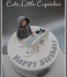 a birthday cake with a little boy sitting at a computer on it's side