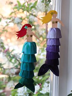 two little mermaids hanging from a window sill