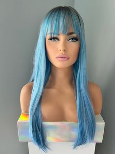 Are you ready to unleash your inner mermaid? "Jade" brings a splash of the seaside to your look with its 24" long, light blue synthetic locks and realistic dark root, all topped off with bangs! It's the perfect way to be a mermaid - no ocean required! Greenish Blue Hair, 24 Inch Wig, Blue Wig With Bangs, Change Up Your Look, Blue Wig, Long Lights, Wig With Bangs, Dark Roots, Greenish Blue