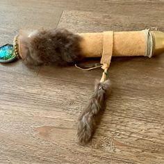 an odd looking object is laying on the floor next to a feather ornament