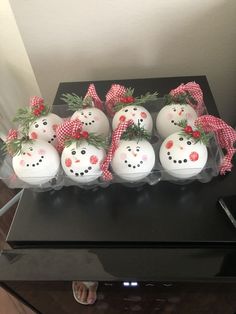 six snowmen with bows on their heads in plastic containers