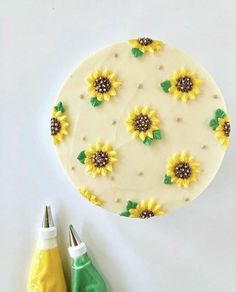 a cake decorated with sunflowers and green leaves on top of a white table