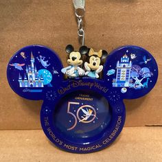 mickey and minnie mouse keychain with disneyland world 50th anniversary logo on it