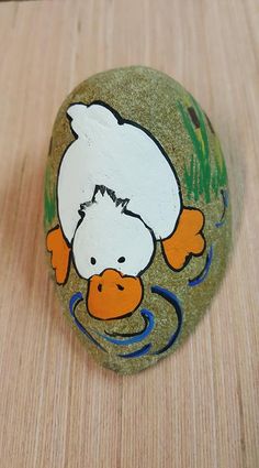 a painted rock with an image of a duck on it