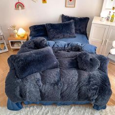 a bed with blue comforters and pillows in a room