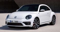 a white volkswagen beetle parked in front of a building